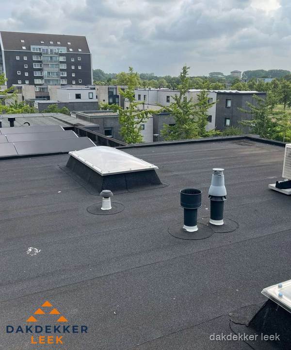 Groot plat dak met lichtkoepel en dakdoorvoeren in Leek
