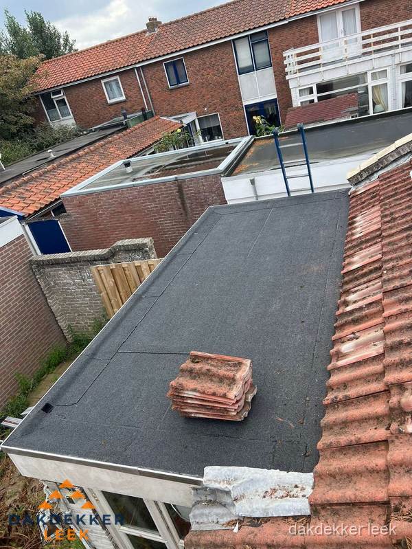 Aanbouw plat dak met reservepannen voor dakpannen vervangen in Leek Aanbouw plat dak met reservepannen voor dakpannen vervangen in Leek