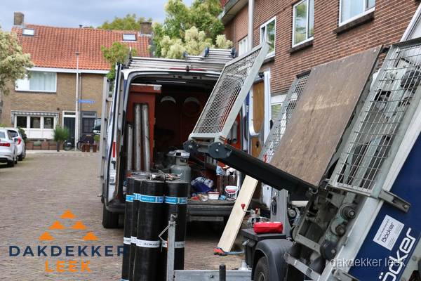 Dakdekkersbusje met materiaal en ladderlift voor dakpannen vervangen in Leek