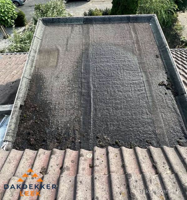Verouderd plat dak met bitumen en slijtage voor lekkage inspectie in Leek Verouderd plat dak met bitumen en slijtage voor lekkage inspectie in Leek