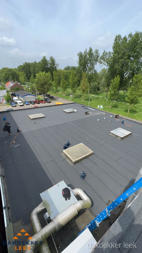 Dakdekker aan het werk op groot plat dak met bitumen in Leek Dakdekker aan het werk op groot plat dak met bitumen in Leek