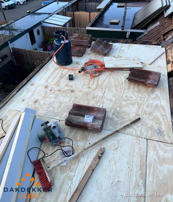 Dakreparatie werkzaamheden op plat dak met gereedschap in Leek Dakreparatie werkzaamheden op plat dak met gereedschap in Leek