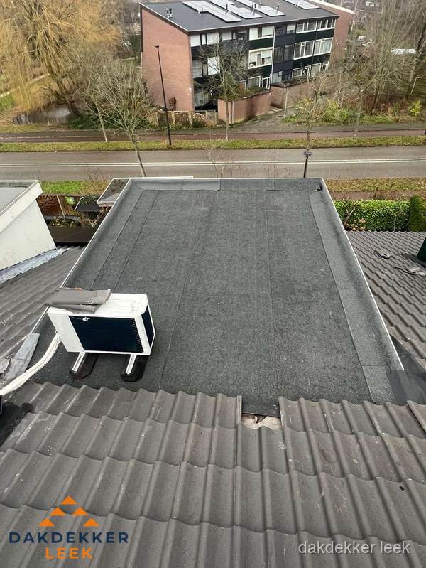 Plat dak inspectie met bitumen bedekking naast schuin pannendak in Leek Plat dak inspectie met bitumen bedekking naast schuin pannendak in Leek